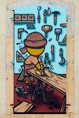 painting of a man working on a piece of wood on a wall