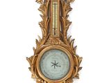 a gold clock mounted on a wall next to a white wall