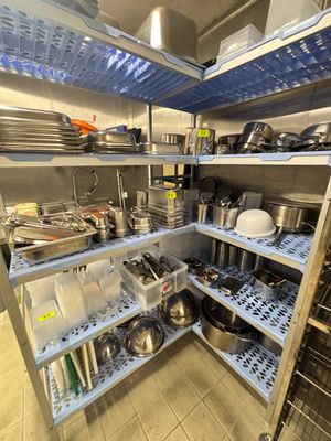 de nombreuses casseroles et poêles sur les étagères de la cuisine