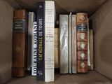 de nombreux livres dans une boîte en carton posée sur la table