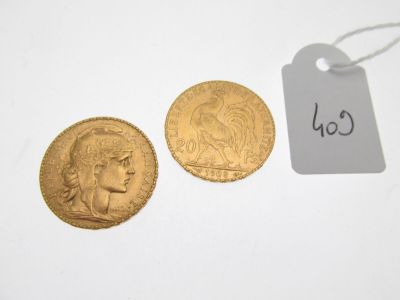 deux pièces d'or posées l'une à côté de l'autre sur une surface blanche