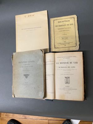 Plusieurs vieux livres sont posés sur une table, à côté d'une paire de chaussures
