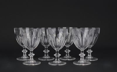 six verres à vin transparents alignés sur une surface noire