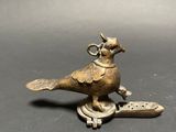 an image of a bronze bird figurine on a black surface