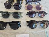 several pairs of sunglasses are on a table with a price tag