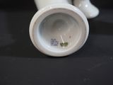 a close up of a white vase on a black table