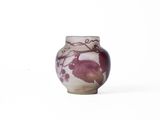 a small vase with a design of leaves on it