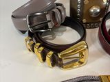 a lot of belts and bracelets that are on a table