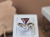 une bague sertie d'une pierre rouge, dans un coffret blanc