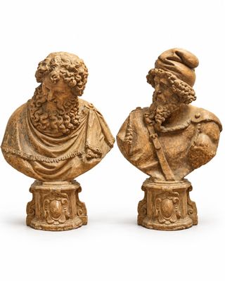 paire de bustes sculptés représentant des hommes portant un chapeau et une barbe