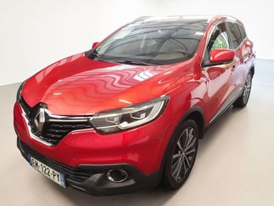 Une voiture rouge est garée dans une pièce blanche