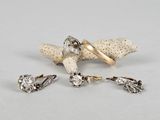 deux bagues en or et diamants et une paire de boucles d'oreilles montées sur un morceau de corail