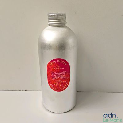 une bouteille argentée sur laquelle est collée une étiquette rouge