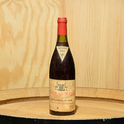 une bouteille de vin posée sur un tonneau