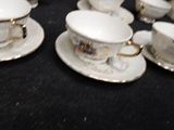 several cups and saucers are lined up on a black table