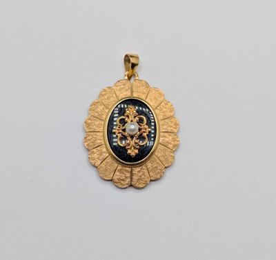 un pendentif en or orné d'un médaillon en noir et blanc
