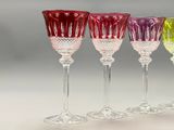 four wine glasses are lined up in a row on a table