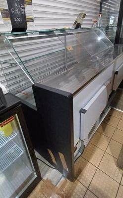 a refrigerated counter with a glass case on it