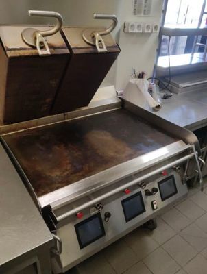 stainless steel counter top in a commercial kitchen with a large oven