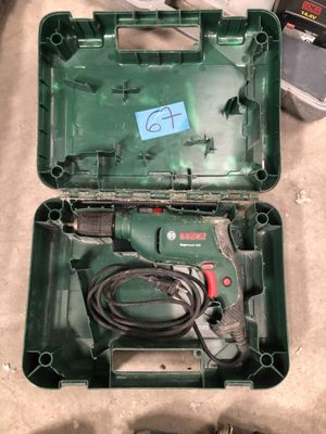 a green box with a cord and a drill in it
