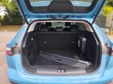 a blue car with its trunk open in the parking lot