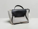 a white and black purse sitting on top of a white table