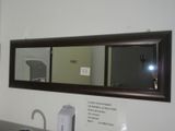 un miroir au-dessus d'un lavabo dans une salle de bains surmontée d'un miroir