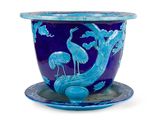un vase bleu orné d'un oiseau, posé sur une soucoupe