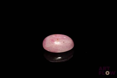 a picture of a pink stone on a black surface
