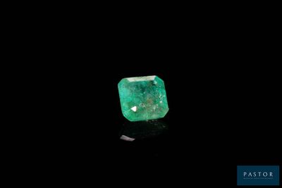 a green emerald stone on a black surface