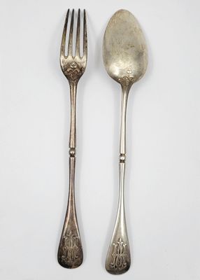 deux cuillères et une fourchette sur une surface blanche