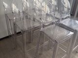 six clear plastic chairs sitting in a row on the floor