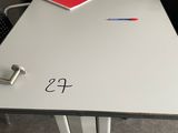 a white table with a red notebook and a black chair