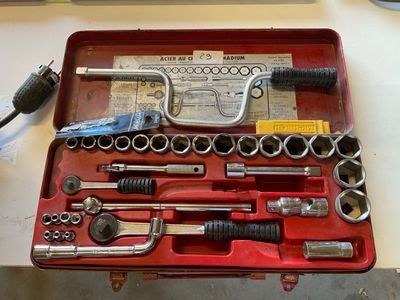 a red tool case with tools in it on a table