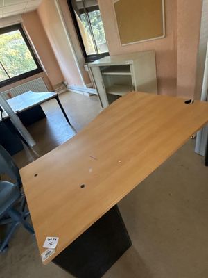 une table en bois au milieu d'une pièce, entourée de chaises bleues