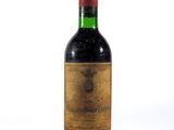 une vieille bouteille de vin posée sur une surface blanche