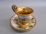a gold cup and saucer on a white table