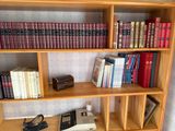 a book shelf with many books and a typewriter on it