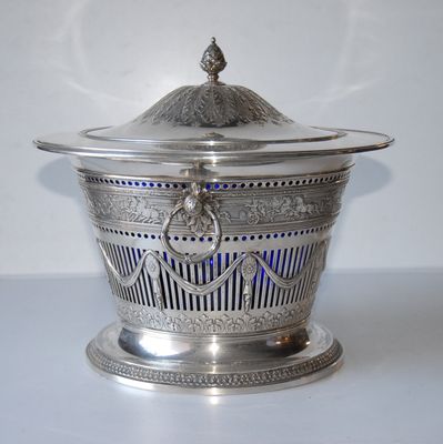 a silver bowl with a lid on a white table