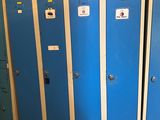plusieurs casiers bleus sont alignés dans une pièce