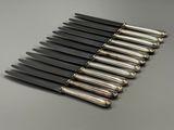 six knives are lined up in a row on a table