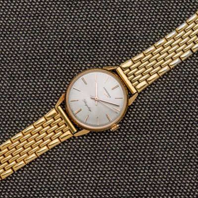 gros plan d'une montre en or sur une surface noire