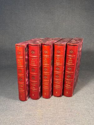 six red books are stacked on top of each other on a gray surface