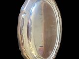 an image of a silver oval mirror on a black background