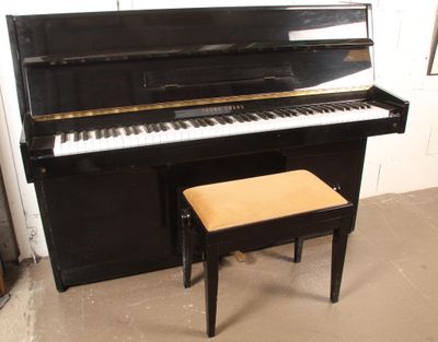 un piano noir et un tabouret dans une pièce
