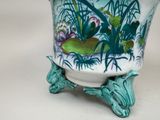 a vase with a painting on it sitting on a stand