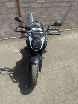 une moto garée sur un parking près d'un mur de briques