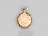une vieille montre de poche en or, ornée d'une pièce de monnaie sur le cadran