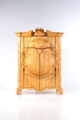 une armoire en bois surmontée d'un oiseau