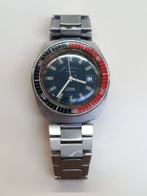 une montre posée sur une surface blanche